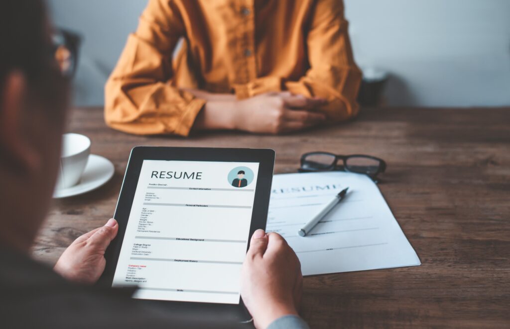 HR managers are interviewing job applicants who fill out their resume on the job application form in order to consider accepting a job as a company.